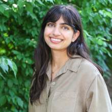 Kanak Kapur stands in front of greenery