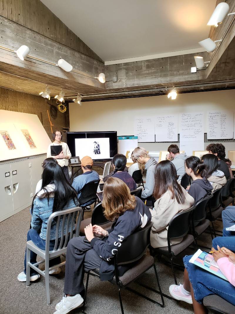A museum employee speaks in front of students