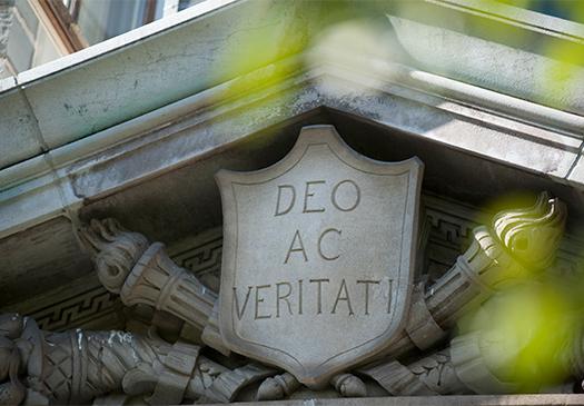 An image of a stone carving with the motto, "Deo Ac Veritati"