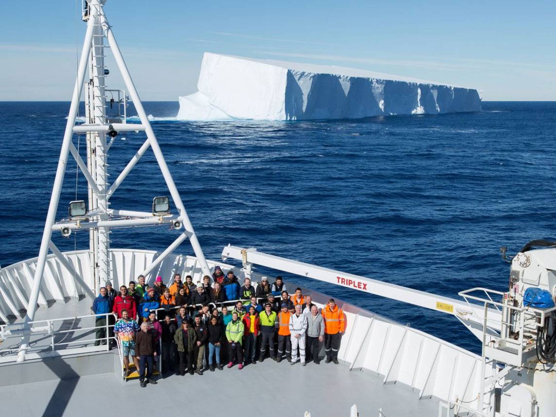Leventer and field team pictured on a boat in front of a glacier